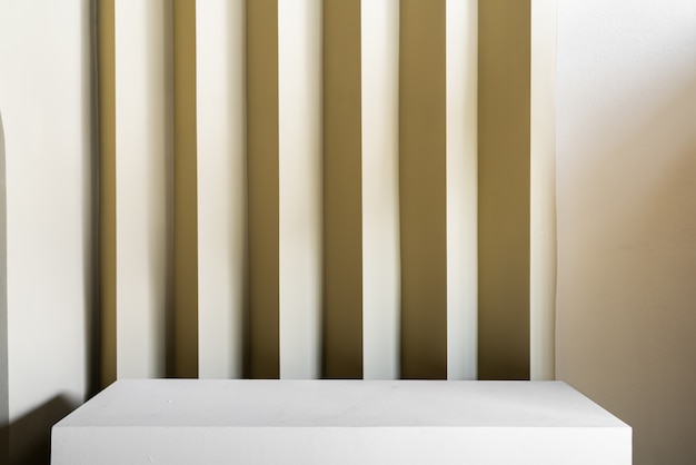 Photo plateau de table de studio avec mur ondulé avec peinture de couleur jaune dans un intérieur de style minimal