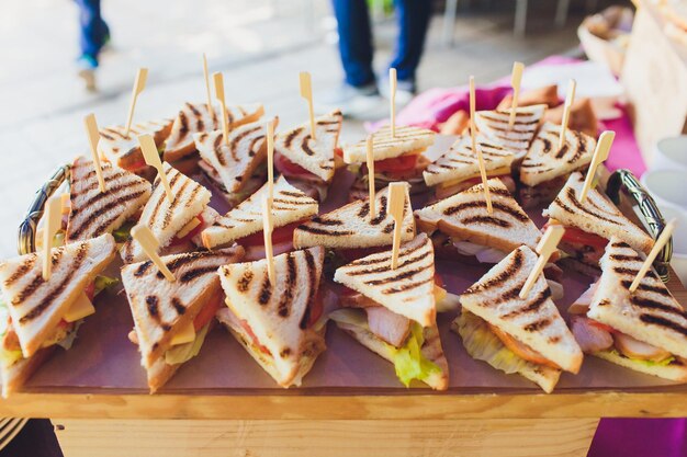 Un plateau de triangles de sandwichs mixtes sur la table du buffet