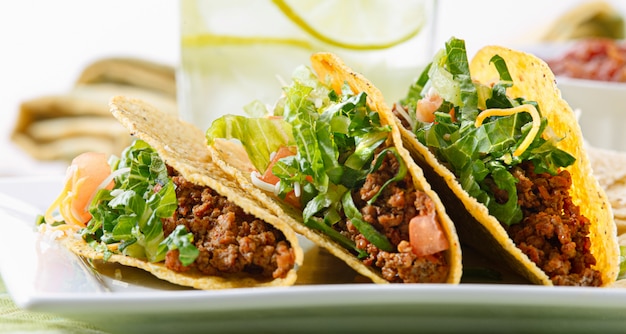 Un plateau de trois tacos sur un plateau blanc