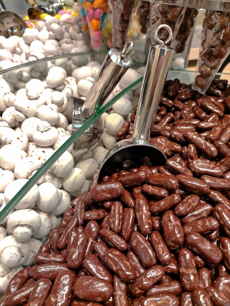 Plateau de vente au poids de dragées chocolat en vrac en magasin Il y a aussi une cuillère pour les verser