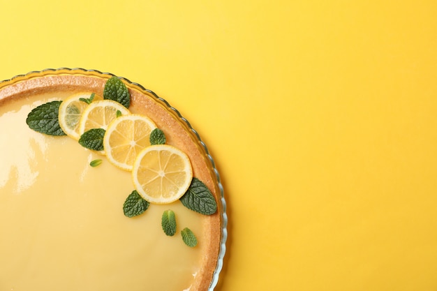 Plateau en verre avec tarte au citron sur jaune, vue de dessus