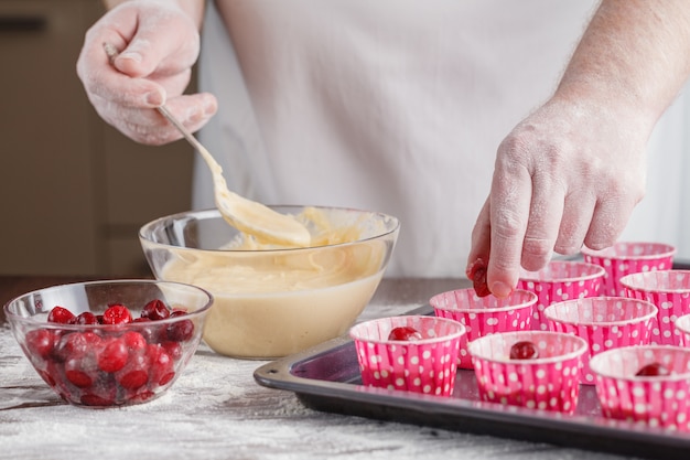 Plateaux de cuisson avec pâte à muffins crue dans des caisses en papier