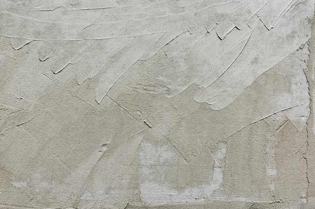 Le plâtre de ciment rugueux est appliqué sur le mur extérieur vertical Fond gris naturel