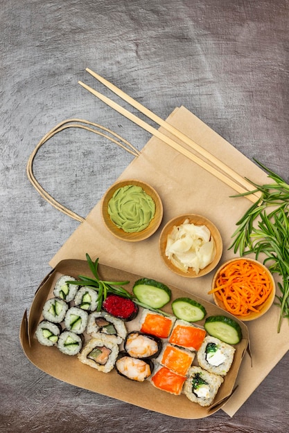 Plats à emporter Sushi et concombres tranchés dans des assiettes en papier Assaisonnements dans des bols