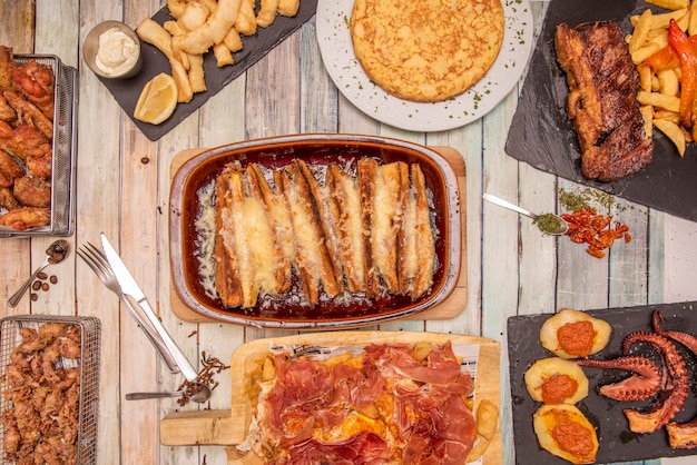 Plats de tapas espagnols populaires servis dans un restaurant puntillitas Omelette espagnole côtes grillées aux poivrons rouges au gratin d'aubergines poulpe grillé