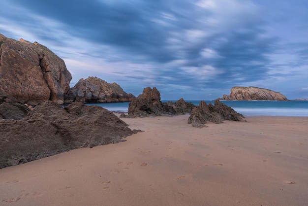 Photo playa de la arnia à santander cantabria au nord de l'espagne avec des rochers flysch et une plage de sable au crépuscule