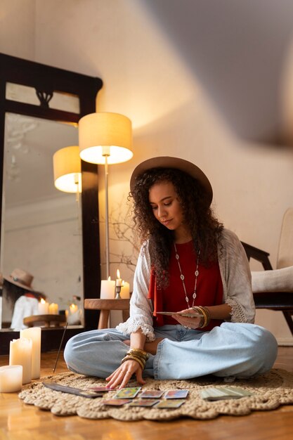 Photo plein coup femme lisant le tarot à la maison