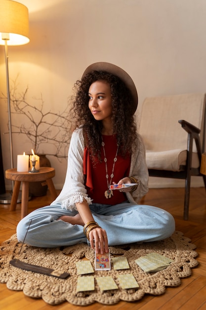 Photo plein coup femme lisant le tarot à la maison