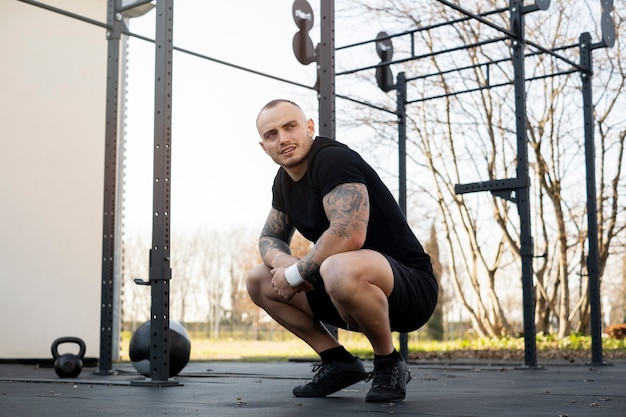 Photo plein coup fit homme assis à l'extérieur