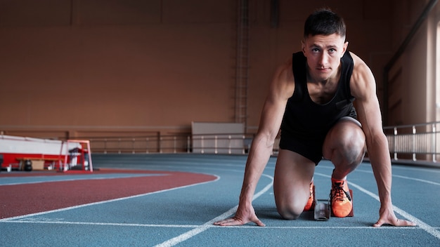 Plein coup fit homme à la ligne de départ en cours d'exécution