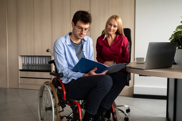 Plein coup homme en fauteuil roulant travaillant