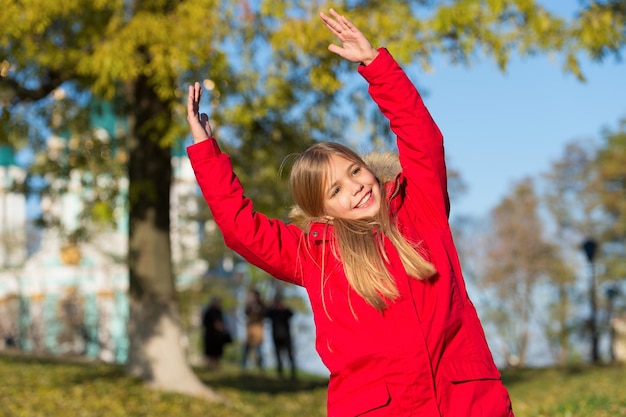 Plein d'énergie vitale Garder le corps au chaud vêtements jours d'automne Concept de tenue d'automne Enfant fille porter un manteau pour la saison d'automne fond nature Enfant joyeux sur la promenade d'automne Manteau chaud meilleur choix pour l'automne