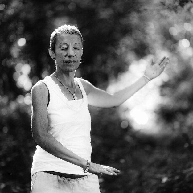 La pleine conscience dans la nature une femme d'âge moyen positive avec les bras ouverts se connectant avec le sentiment de la nature