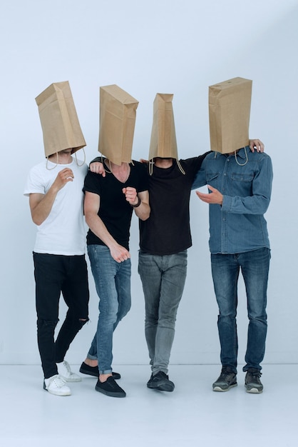 Photo en pleine croissance un groupe d'hommes avec des sacs en papier sur leur tête photo avec espace de copie