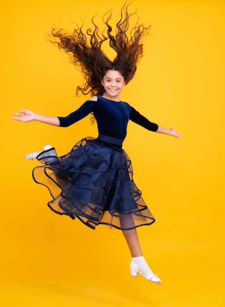 Pleine longueur ravie adolescente enfant fille 12 13 14 ans sautant vieux isolé sur fond jaune studio saut drôle enfant en robe de mouvement d'été