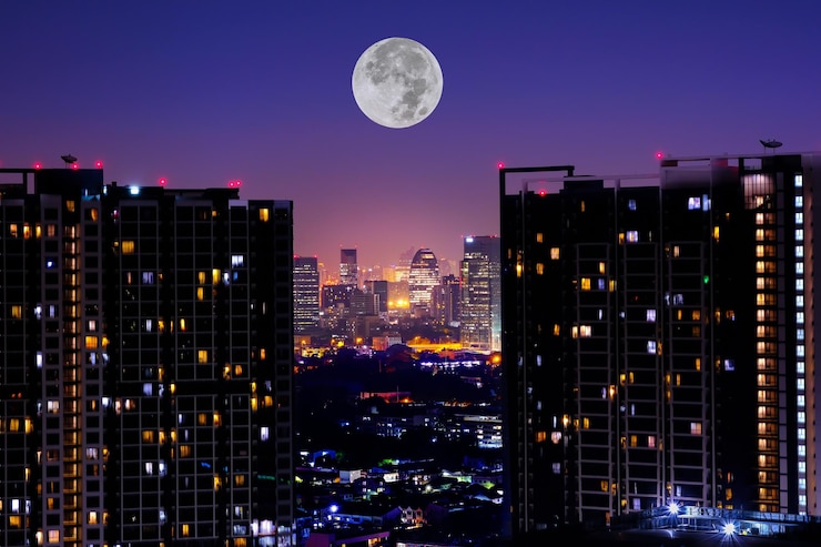 Photo la pleine lune dans la ville contre le ciel la nuit
