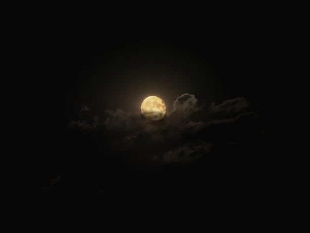 Pleine lune éclairant les nuages