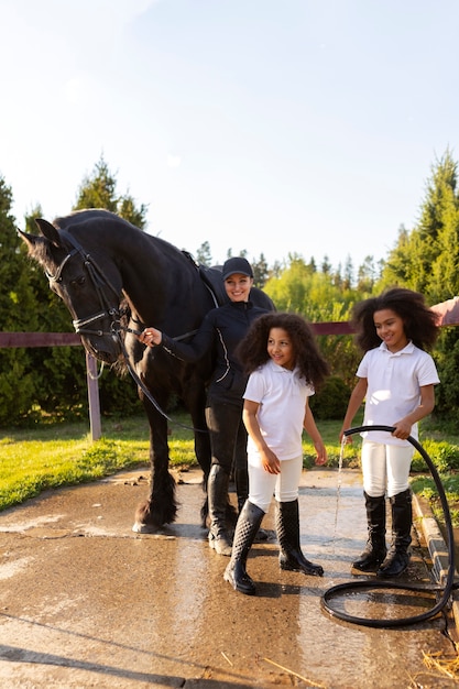 Photo pleine photo d'enfants apprenant à monter à cheval