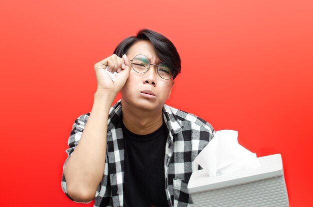 Pleurer l'expression du visage d'un jeune homme asiatique avec un geste de la main isolé sur fond rouge