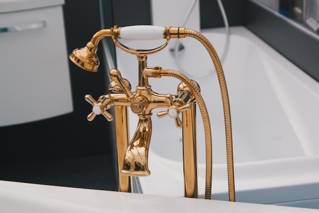 Plomberie en or riche sur bain blanc dans la salle de bain, vue rapprochée