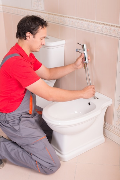 Un plombier réparant des toilettes dans l'appartement.