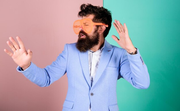 Plonger dans la célébration Lunettes de fête homme barbu célébrant Hipster dans des lunettes extravagantes accessoire de mode célébrant les vacances Homme avec une longue barbe tenue de cérémonie Homme d'affaires ludique célébrant