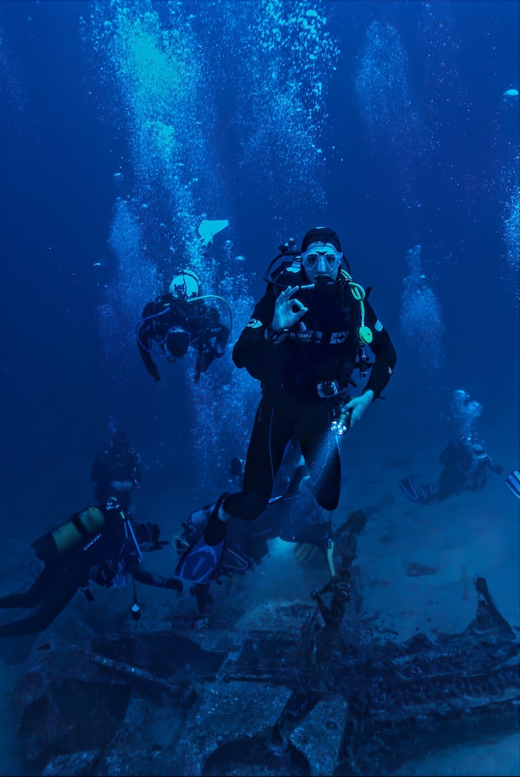 Photo un plongeur dans un océan bleu avec un certain nombre de plongeurs au fond.