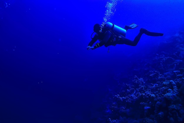 plongeurs sous l'eau en profondeur dans le fond bleu de la mer