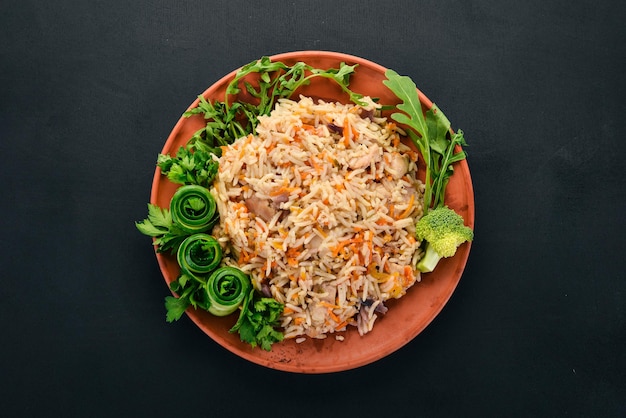 Plov Riz avec de la viande et des légumes sur une assiette Cuisine ouzbèke Sur un fond en bois Vue de dessus Espace de copie