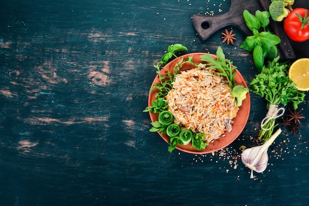 Plov Riz avec de la viande et des légumes sur une assiette Cuisine ouzbèke Sur un fond en bois Vue de dessus Espace de copie