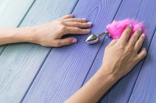 Plug anal avec une queue rose pelucheuse avec des mains féminines Jouet pour jeux pour adultes