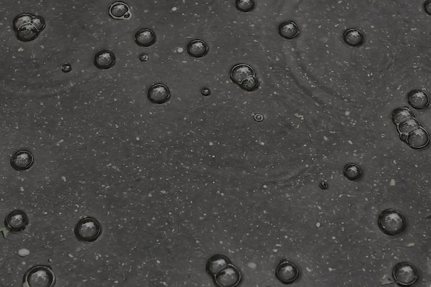 pluie de flaque d'arrière-plan / cercles et gouttes dans une flaque d'eau, texture avec bulles dans l'eau, pluie d'automne