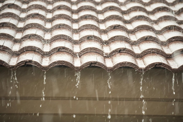 Pluie tombant du toit de la maison