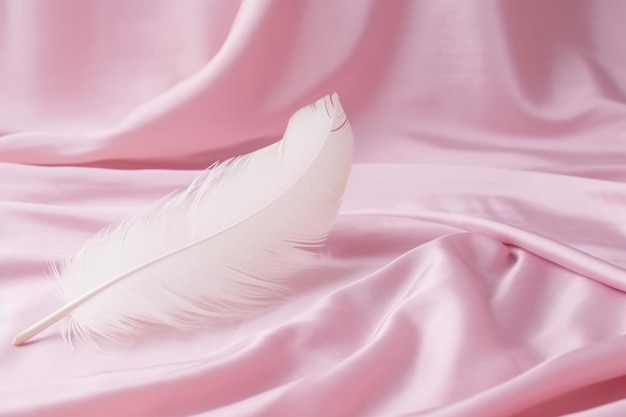 Une plume blanche est posée sur un tissu rose