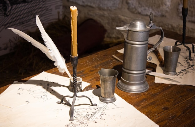 Plume et bougie antiques Les objets délabrés sur la table sont une bougie de cire et une plume