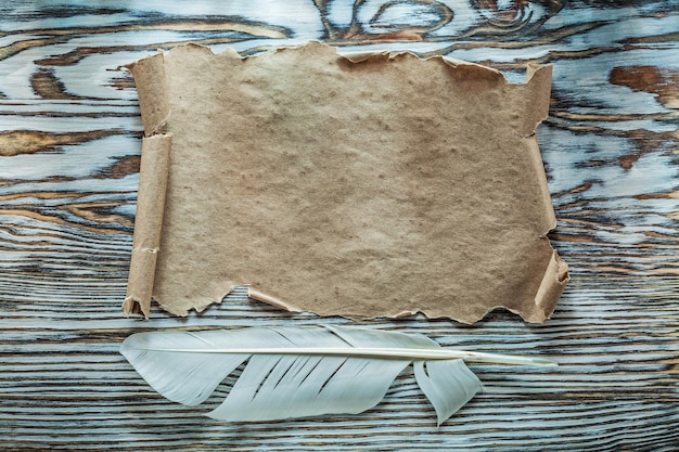 Plume de défilement de papier vintage sur planche de bois.