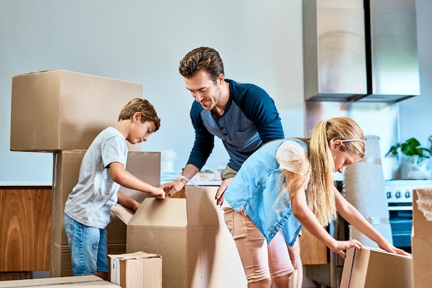 Plus de mains font moins de travail Photo d'une jeune famille concentrée travaillant ensemble et déballant des cartons dans leur nouvelle maison à l'intérieur pendant la journée