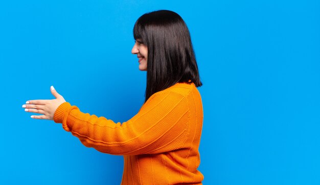 Plus la taille jolie femme souriante, vous saluant et vous offrant une poignée de main pour conclure un accord réussi, concept de coopération