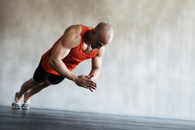 Plus vite, plus fort, plus fort. Plan d'un homme faisant des exercices au gymnase.