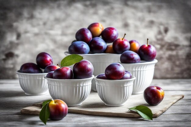 Photo plusieurs bols de prunes sont sur une table dont l'un a une feuille dessus