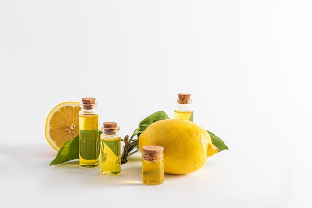 Plusieurs bouteilles avec un bouchon avec un produit cosmétique naturel à base d'huile essentielle de citron sur fond blanc vue de face présentation du produit