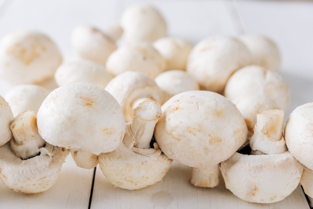 Plusieurs champignons sur un fond en bois blanc