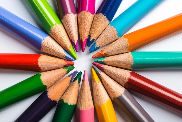 Plusieurs crayons de couleur sur une feuille de papier blanc