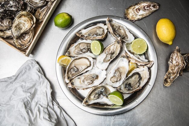 Plusieurs huîtres ouvertes au citron et citron vert.