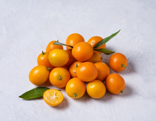 Plusieurs kumquats sucrés frais juteux sur une table en bois blanc