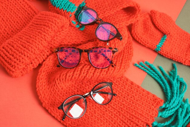 Plusieurs lunettes élégantes différentes sur une écharpe tricotée rouge, vente de noël dans un magasin d'optique, montures de lunettes à la mode