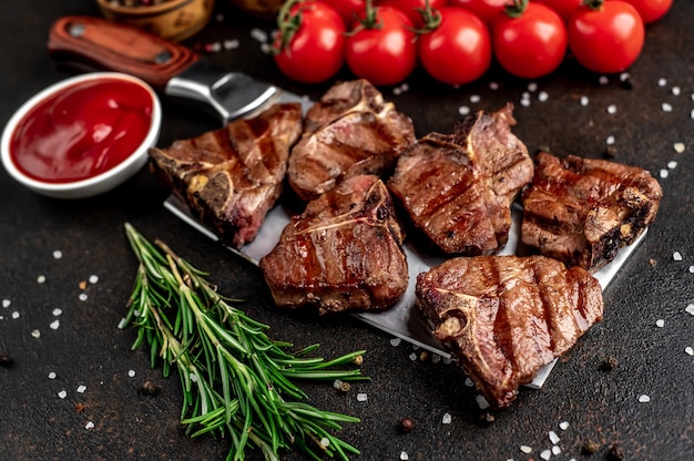 Plusieurs mini steaks de boeuf grillé T-Bone sur le couteau sur la table en pierre