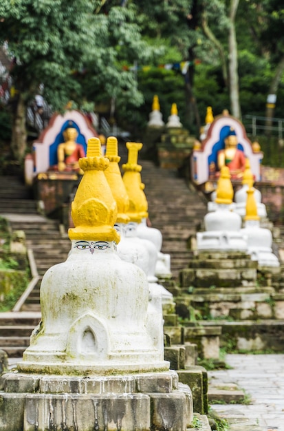 Plusieurs petits stupas blancs avec la peinture traditionnelle "Eyes of Buddha" dans une rangée dans le temple de Swayambhunath, également appelé Monkey Temple. Ville de Katmandou, voyage au Népal concept.