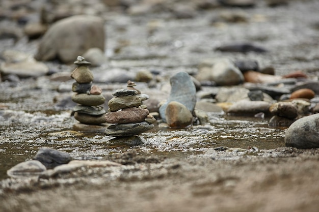 Plusieurs piles de roches interrompent l'écoulement de l'eau dans le ruisseau.