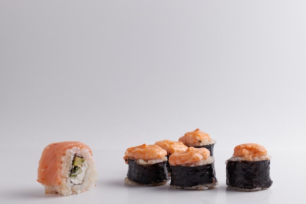 Plusieurs rouleaux différents sur la table, cuisine asiatique, vue latérale, fond clair, sushi, gingembre et wasabi